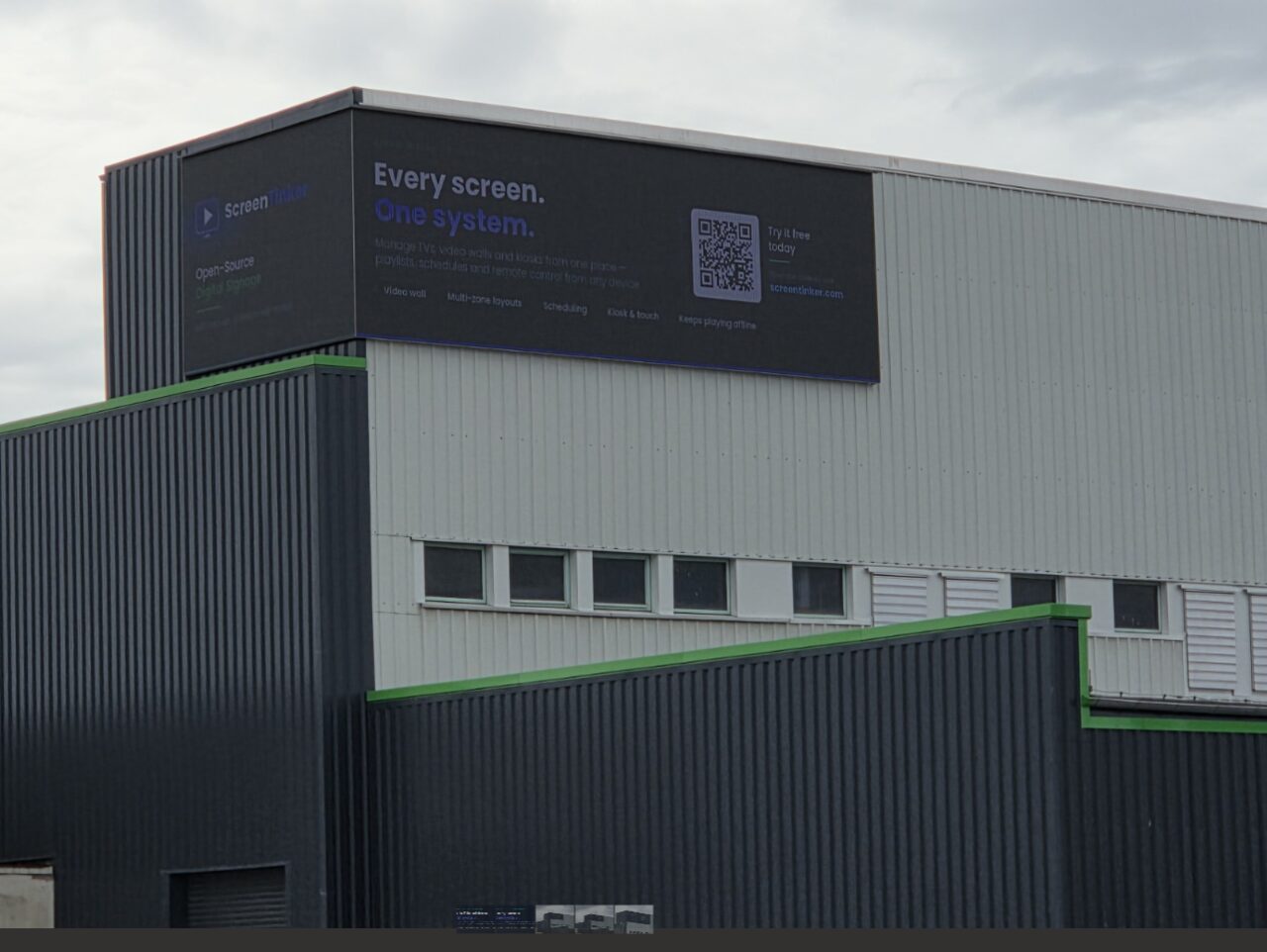 A OnVidiOn advert running on a large outdoor LED video wall mounted on an industrial building